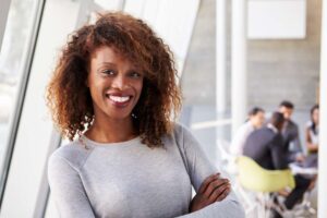 Smiling woman in white sweater with arms crossed