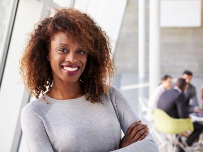Smiling woman in white sweater with arms crossed