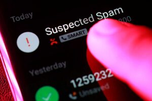 Finger pointing at suspected spam call on smartphone