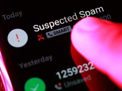 Finger pointing at suspected spam call on smartphone