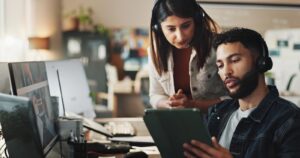 Woman and man with tablet in technical support office.