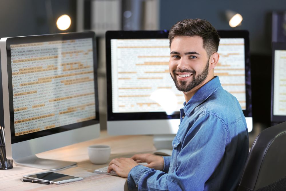 IT Professional at his desk with two monitors
